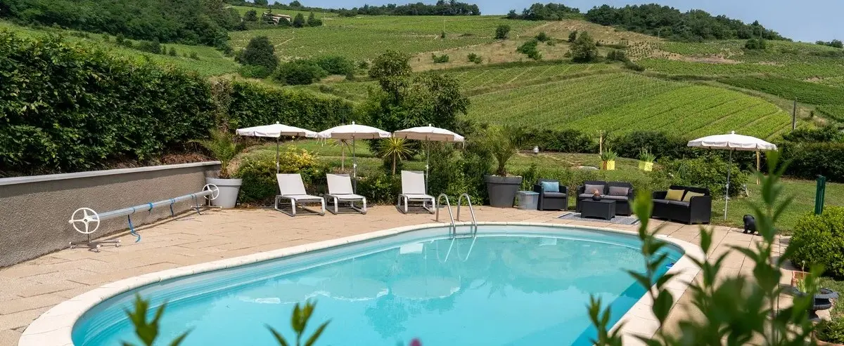 Piscine chauffée Villa Saint-Lager vue panoramique vignes Beaujolais transat détente luxe